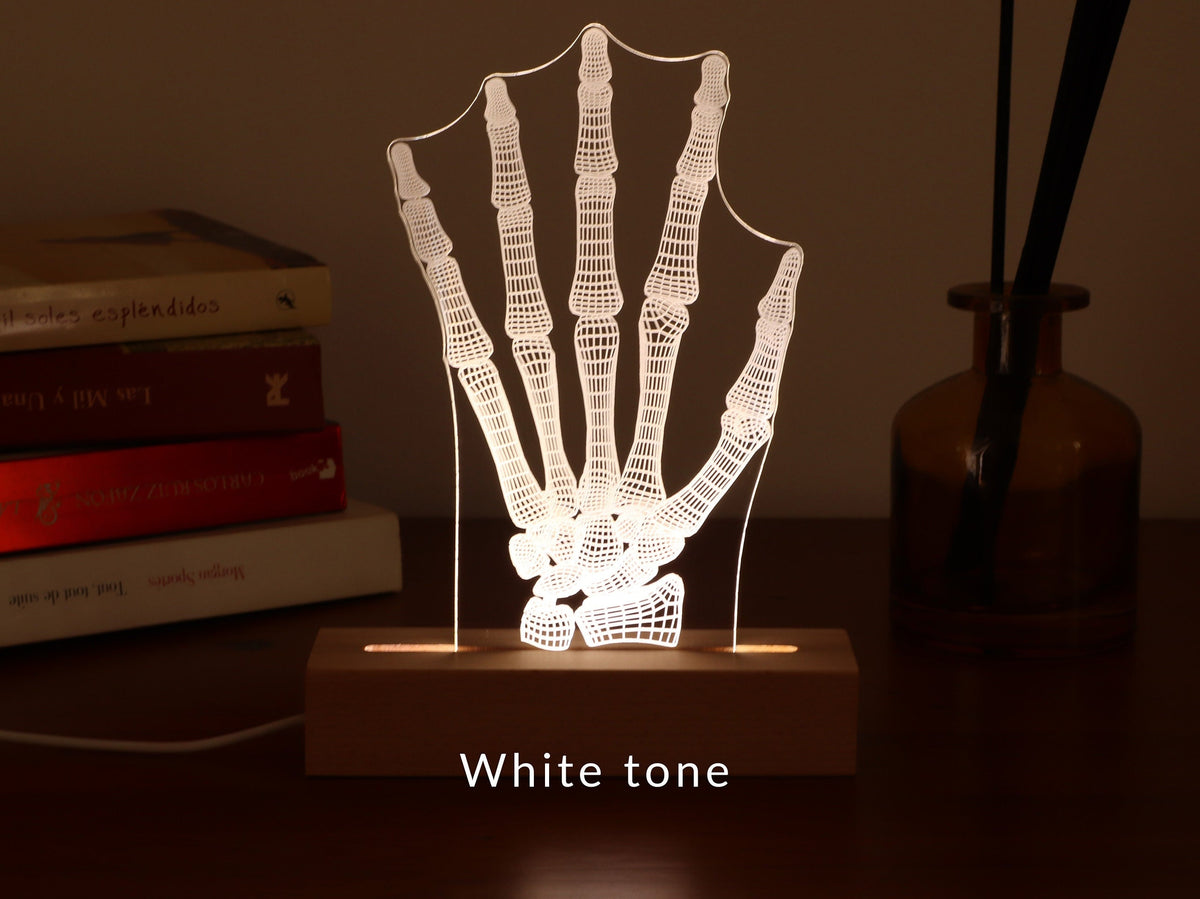 3D illusion lamp featuring a detailed human hand bone anatomy design, illuminated in a white tone, perfect as a unique and thoughtful gift for orthopedic specialists, physiotherapists, or medical professionals focusing on hand health.